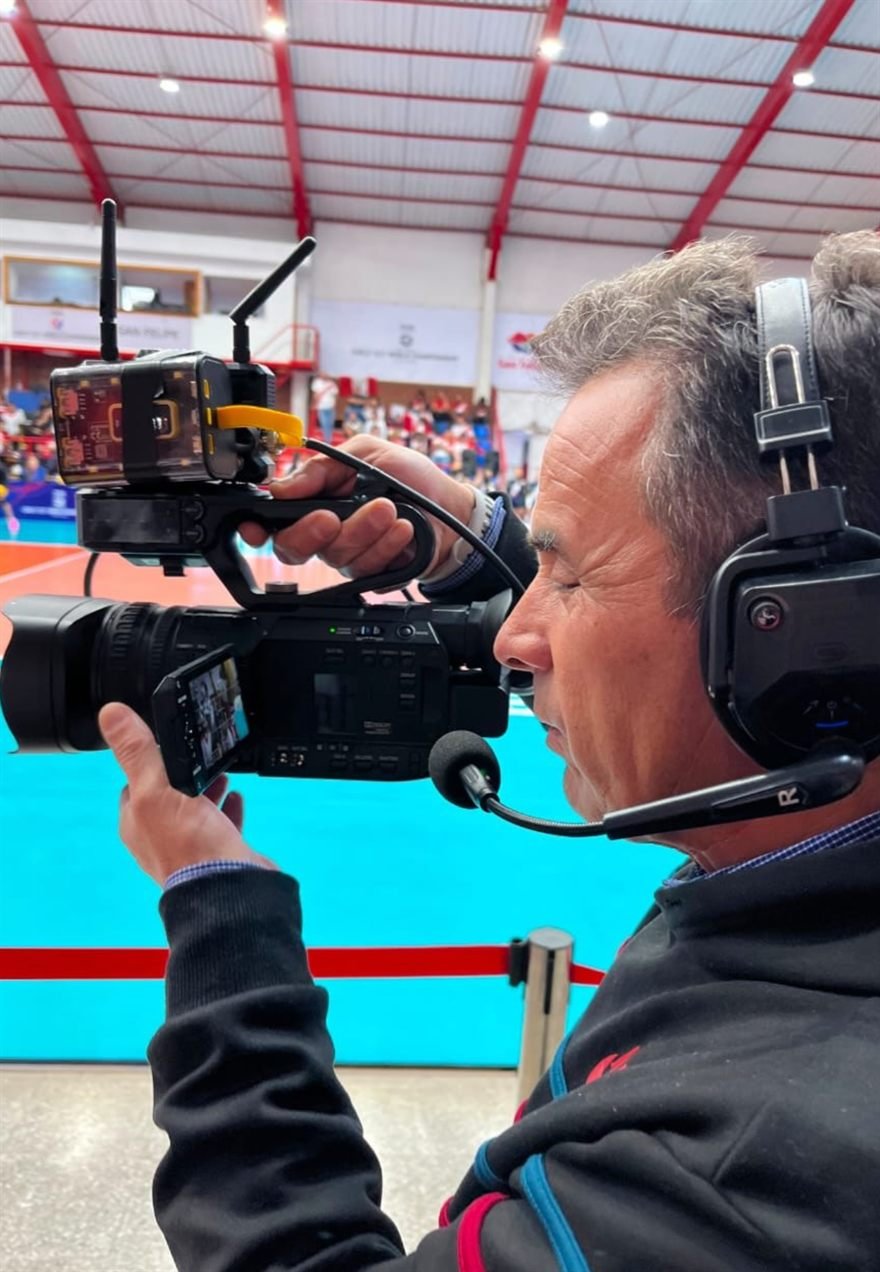 Camarógrafo con intercom operando una cámara durante un partido: la señal entra al sistema.